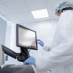Cientista usa um monitor touchscreen em um laboratório moderno.