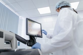 Cientista usa um monitor touchscreen em um laboratório moderno.