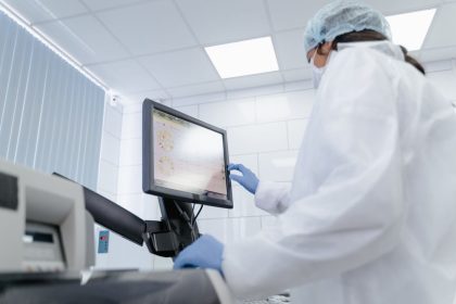 Cientista usa um monitor touchscreen em um laboratório moderno.