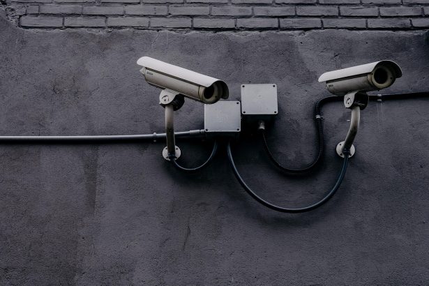 Câmera de vigilância instalada em uma parede, usada para monitoramento de segurança.