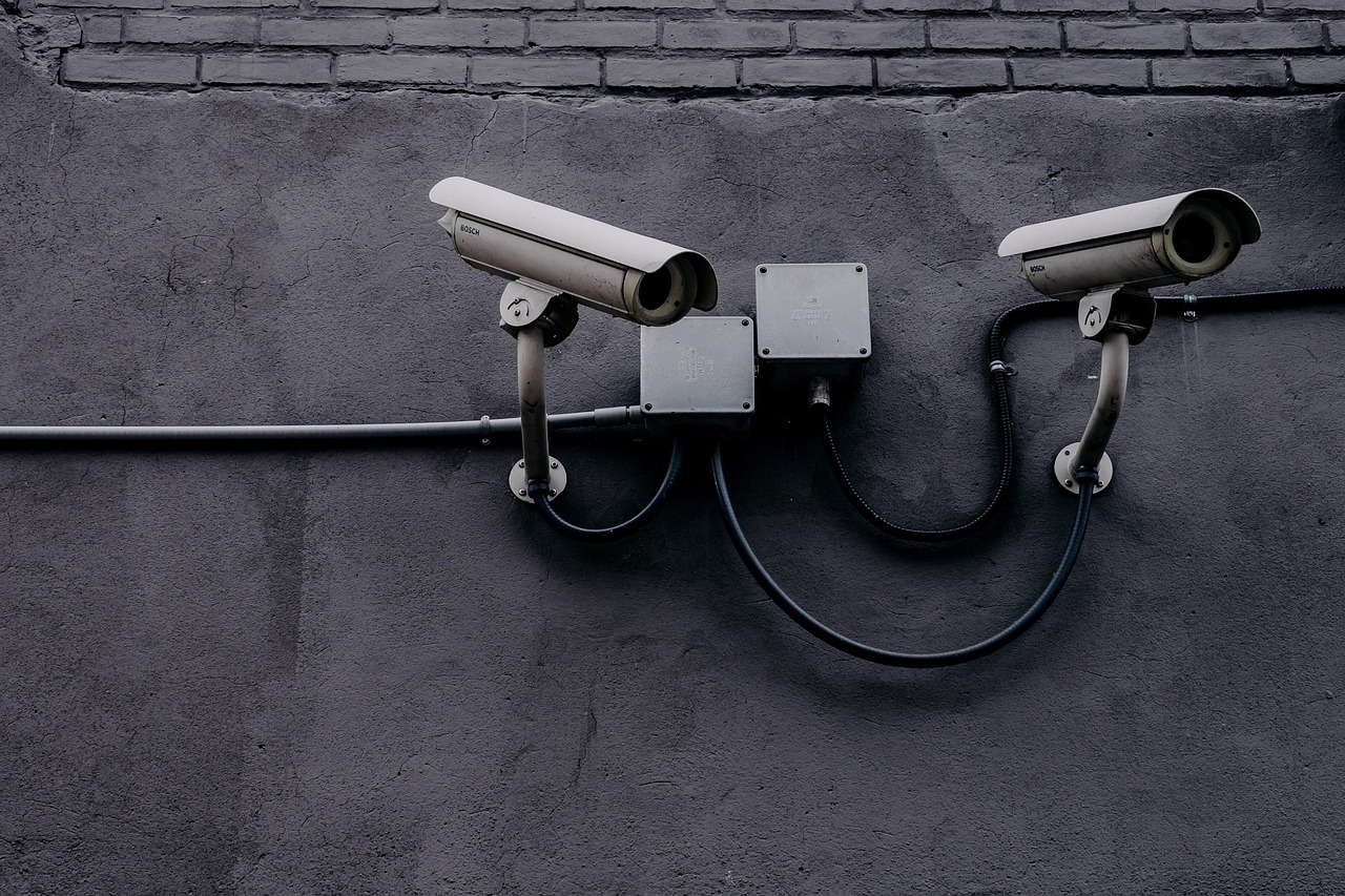 Câmera de vigilância instalada em uma parede, usada para monitoramento de segurança.